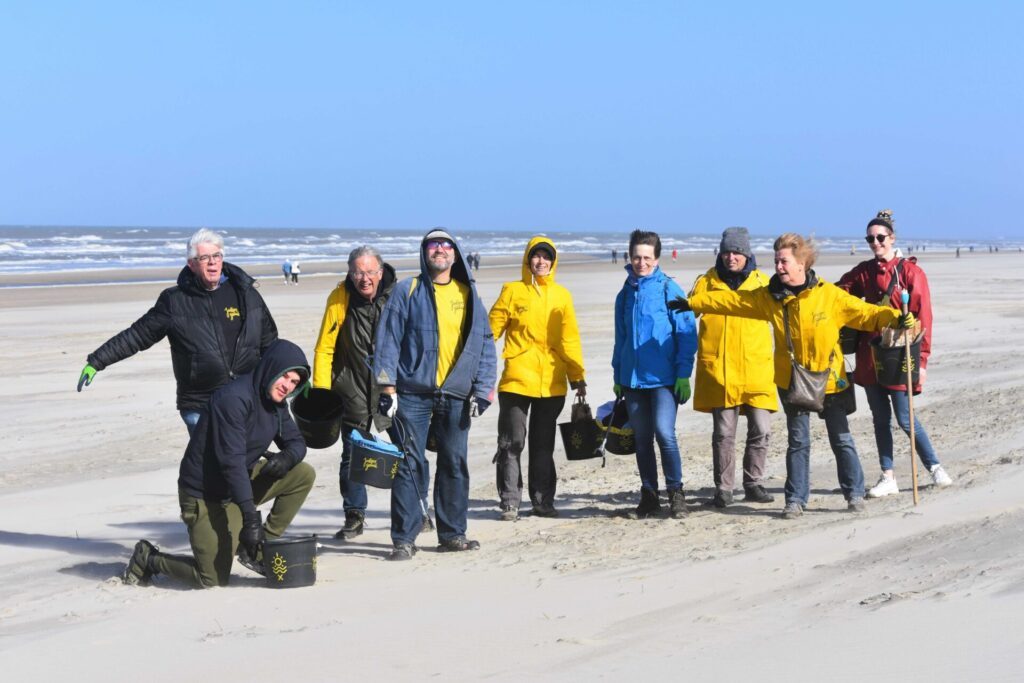 Groep vrolijke mensen op het strand in de wind. 