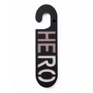 Zwarte kartonnen deurhanger met het woord hero in taupe en wit