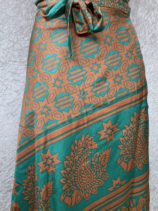 Wikkelrok passend van maat XS tot en met XXL. Gemaakt van twee vintage sari's uit India. De rok valt tot aan de enkel. De rok is aan twee zijden draagbaar, ofwel reversible. Voor en achterkant verschillen volledig van elkaar. Superleuk, upcycled en sustainable kledingstuk voor in je garderobe, en ook heerlijk voor mee op reis-want je hebt een 2 in 1 rok!